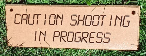 Caution shooting in progress wooden sign